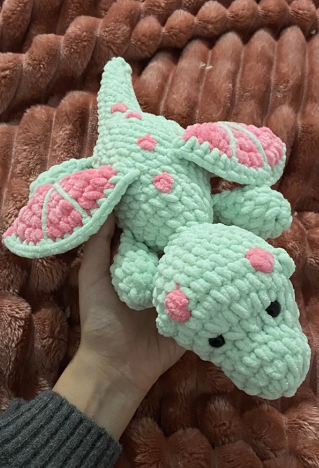 Cute handmade green and pink plush toy made with the free no-sew crochet dragon pattern