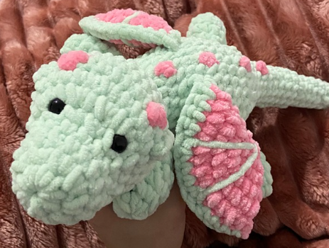Cute handmade green and pink plush toy made with the free no-sew crochet dragon pattern