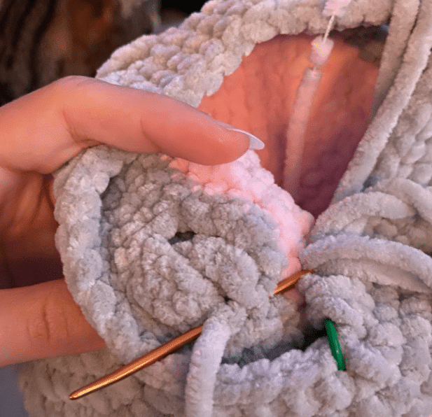 sewing the fins to the crochet turtle