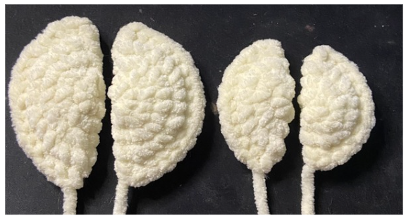 Individual white plush crochet fins folded in half and edged with single crochets.