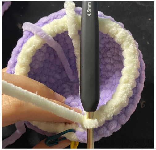 Purple textured amigurumi turtle shell showing the front loops only (FLO) round and openings for the fins.