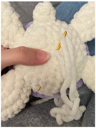 Purple textured amigurumi turtle shell showing the front loops only (FLO) round and openings for the fins.