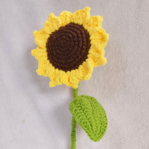 Handmade crochet sunflower amigurumi with a realistic brown center, vibrant yellow petals, and a green wired stem