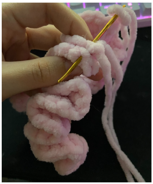Close-up of the ruffled pink crochet tutu skirt wrapped around the handmade amigurumi hippo.