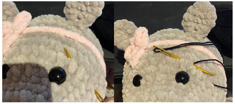Close-up of the embroidered facial features, showing black cotton thread shaping the eyebrows and nostrils on the hippo's snout.