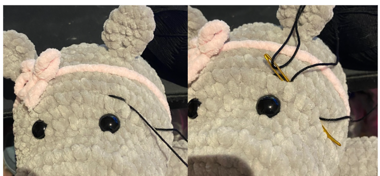 Close-up of the embroidered facial features, showing black cotton thread shaping the eyebrows and nostrils on the hippo's snout.