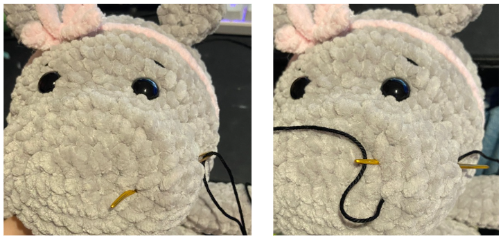 Close-up of the embroidered facial features, showing black cotton thread shaping the eyebrows and nostrils on the hippo's snout.