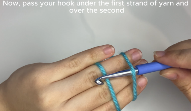 Inserting crochet hook under and over yarn strands to create a magic circle loop.