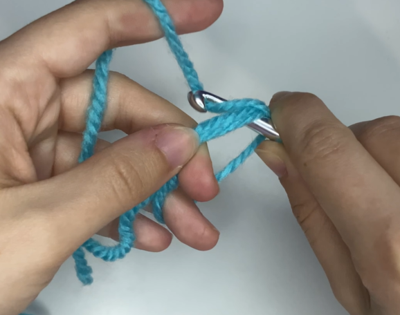 Working single crochet stitches into the center of an adjustable magic ring.