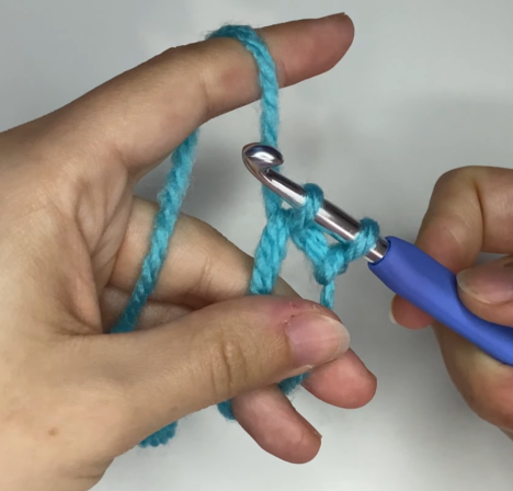 Working single crochet stitches into the center of an adjustable magic ring.