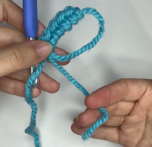 Gently pulling the yarn tail to close the magic ring completely for amigurumi.