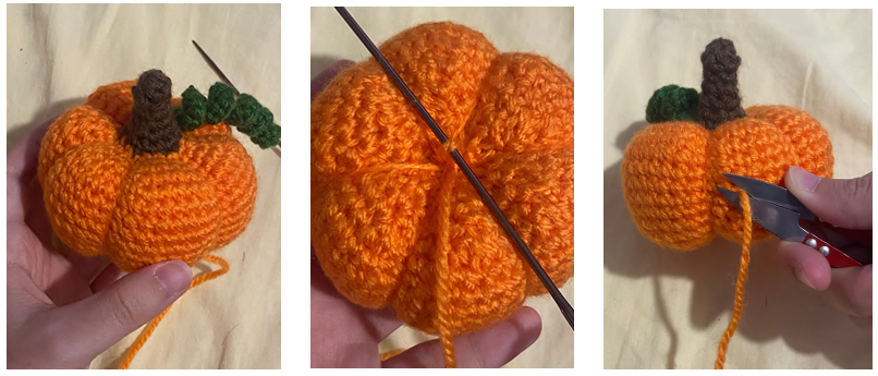 Using a yarn needle to pull yarn through the center to shape the segments of a handmade crochet pumpkin.