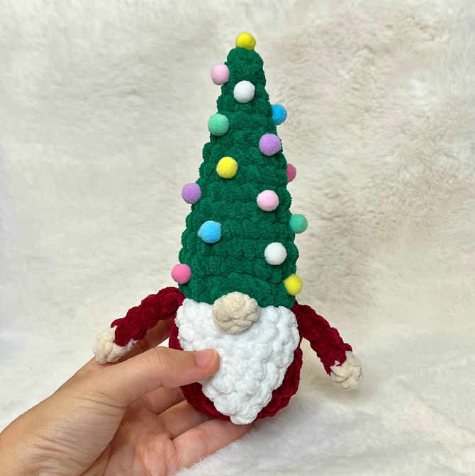 Free Christmas gnome crochet pattern finished plushie made with green chenille yarn and colorful pom-pom ornaments.