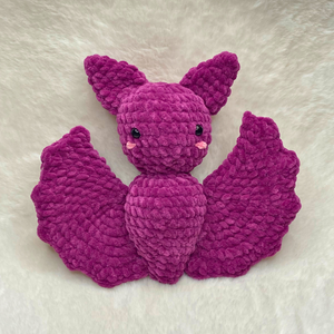 Handcrafted purple plush bat crochet amigurumi made with bulky chenille yarn, featuring big ears and spread wings against a clean background.