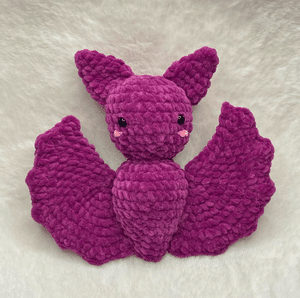 Handcrafted purple plush bat crochet amigurumi made with bulky chenille yarn, featuring big ears and spread wings against a clean background.