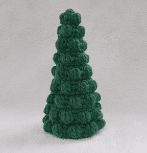 Handcrafted green bobble Christmas tree crochet amigurumi made with textured stitches against a neutral background.