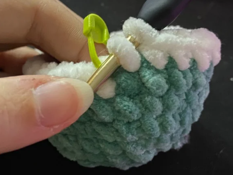 Step by step crochet duck head in green yarn showing color change to white ring and brown body.