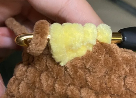 No sew crochet duck body showing yellow bobble stitch feet and continuous brown plush body.