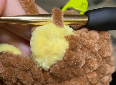 No sew crochet duck body showing yellow bobble stitch feet and continuous brown plush body.