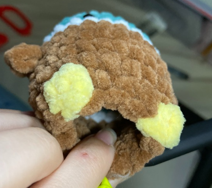 No sew crochet duck body showing yellow bobble stitch feet and continuous brown plush body.