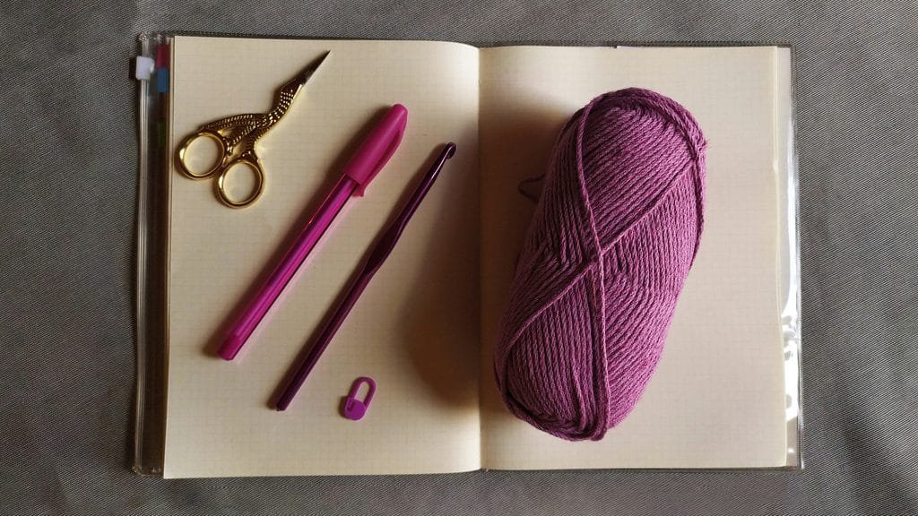 crochet supplies on a notebook.